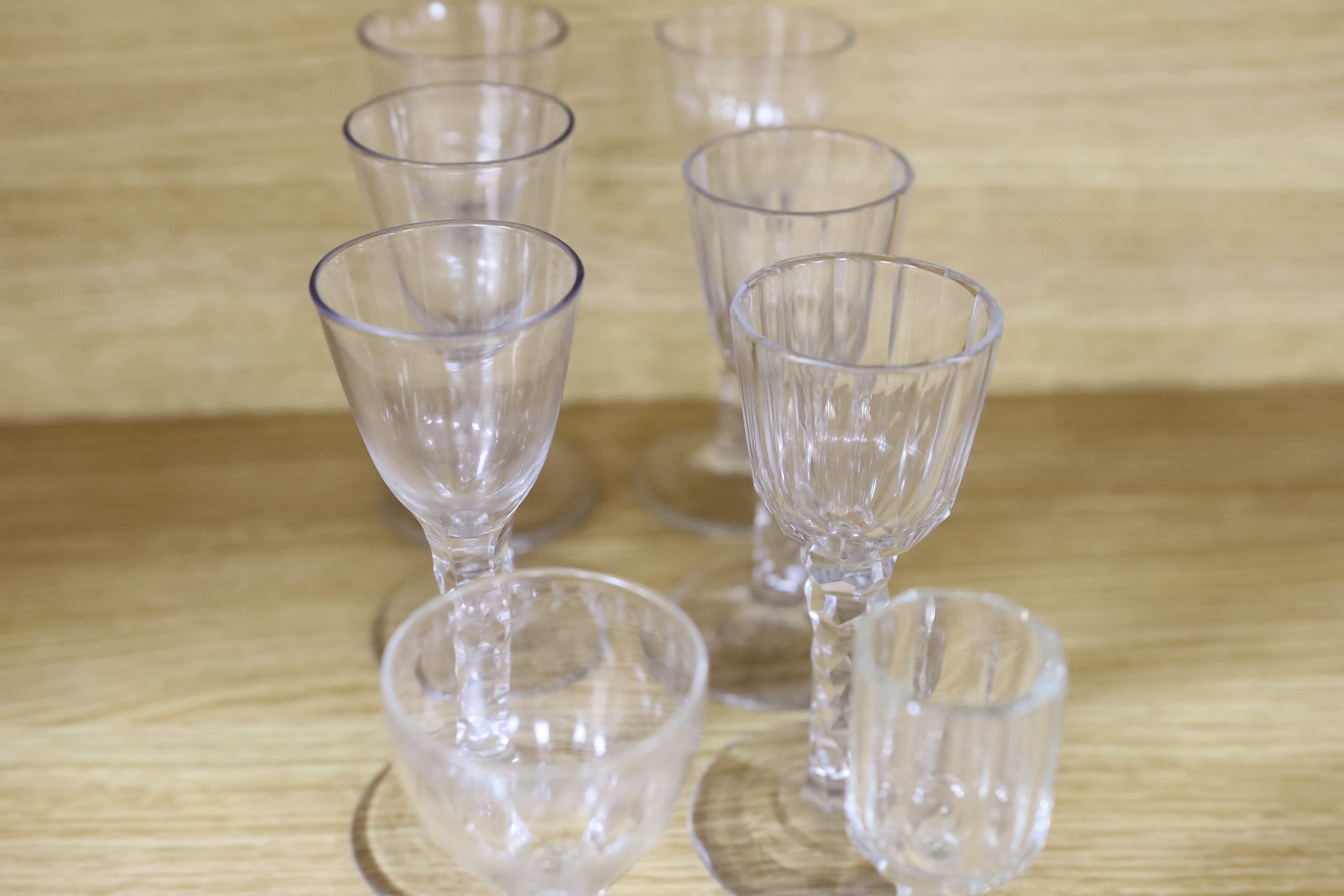 A collection of seventeen late 18th century drinking glasses, consisting of a set of four facet cut stemmed wines, a set of five small liqueurs with gilt star painted bowls and three various wine glasses (12)